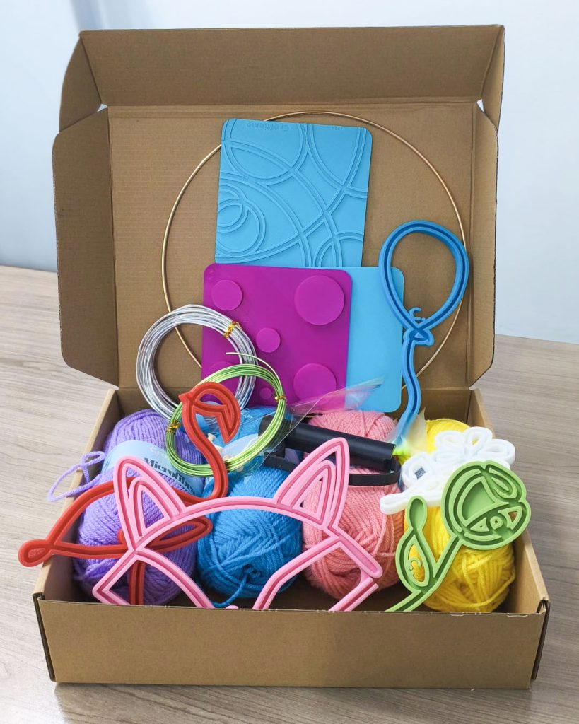 kit per ambassador Craftiamo con telai filoforma in una scatola di cartone insieme a gomitoli di lana
